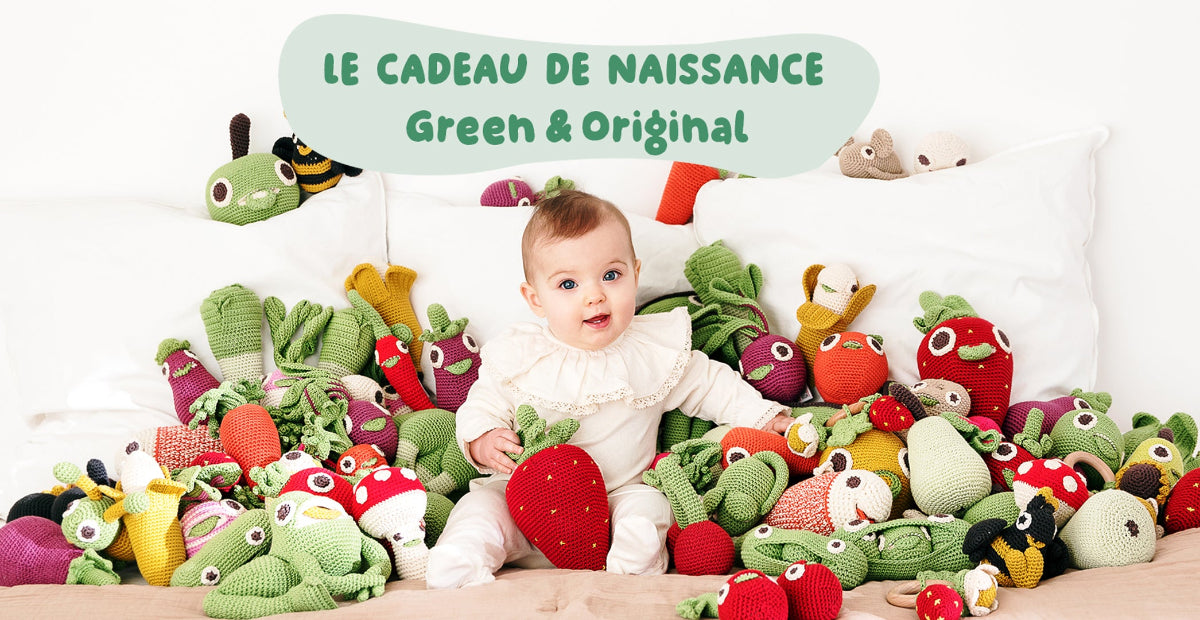bébé dans un chambre d'enfant avec des jouets fait main au crochet en coton biologique en forme de fruits et légumes Image