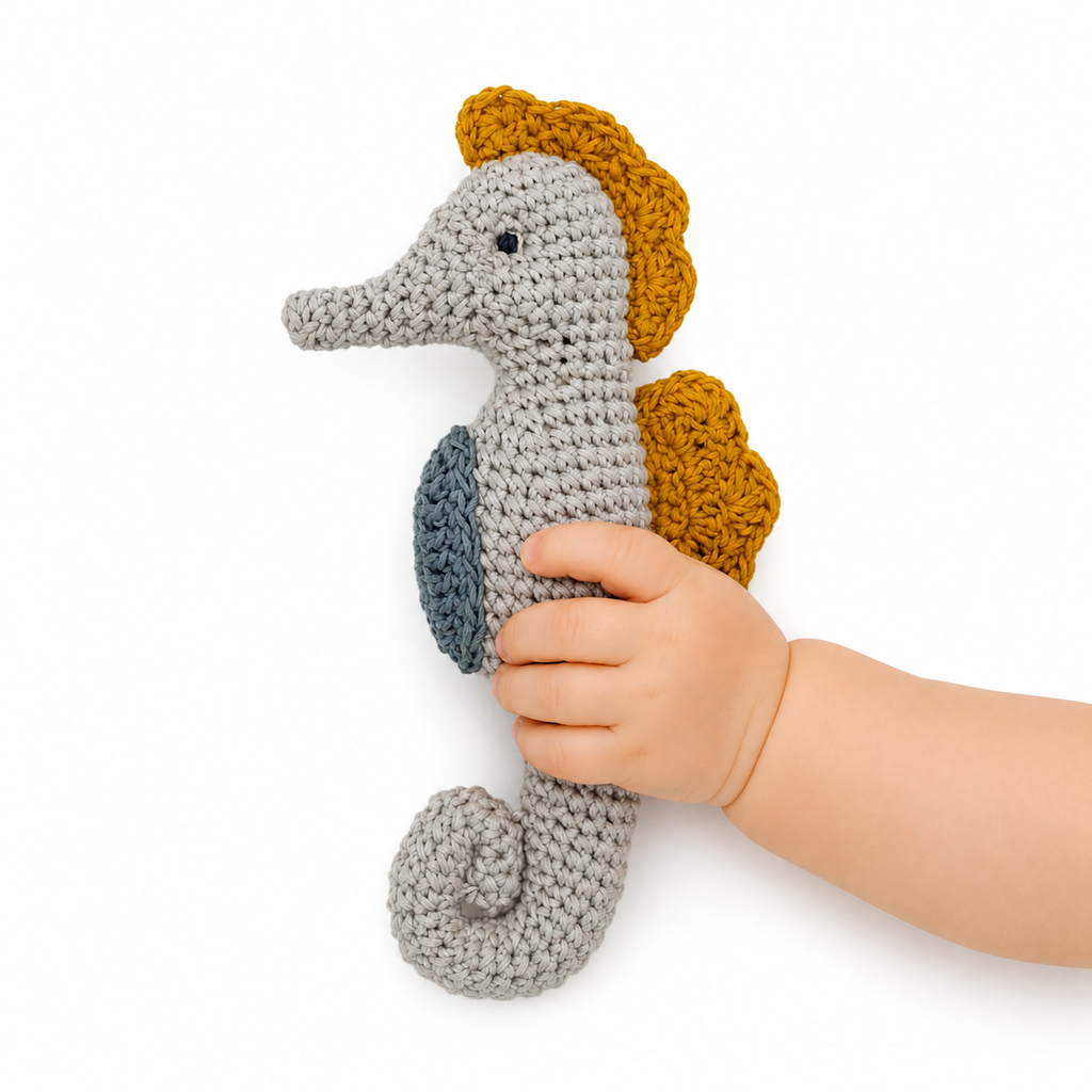 jouet crochet hochet  dans la main de bébé hippocampe