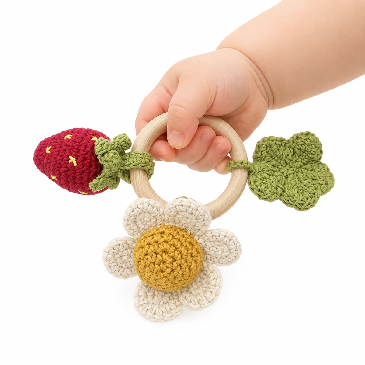 jouet crochet teether dans main de bébé printemps fraise fleur