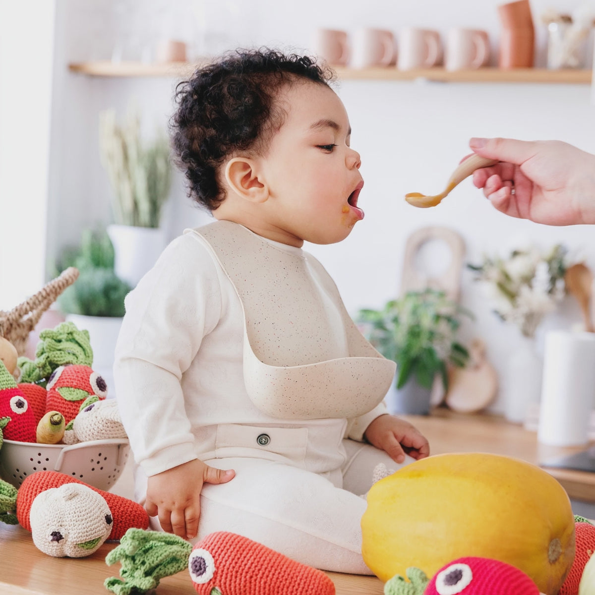 bebe dans une cuisine qui mange et joue avec ces fruits et legumes MYUM